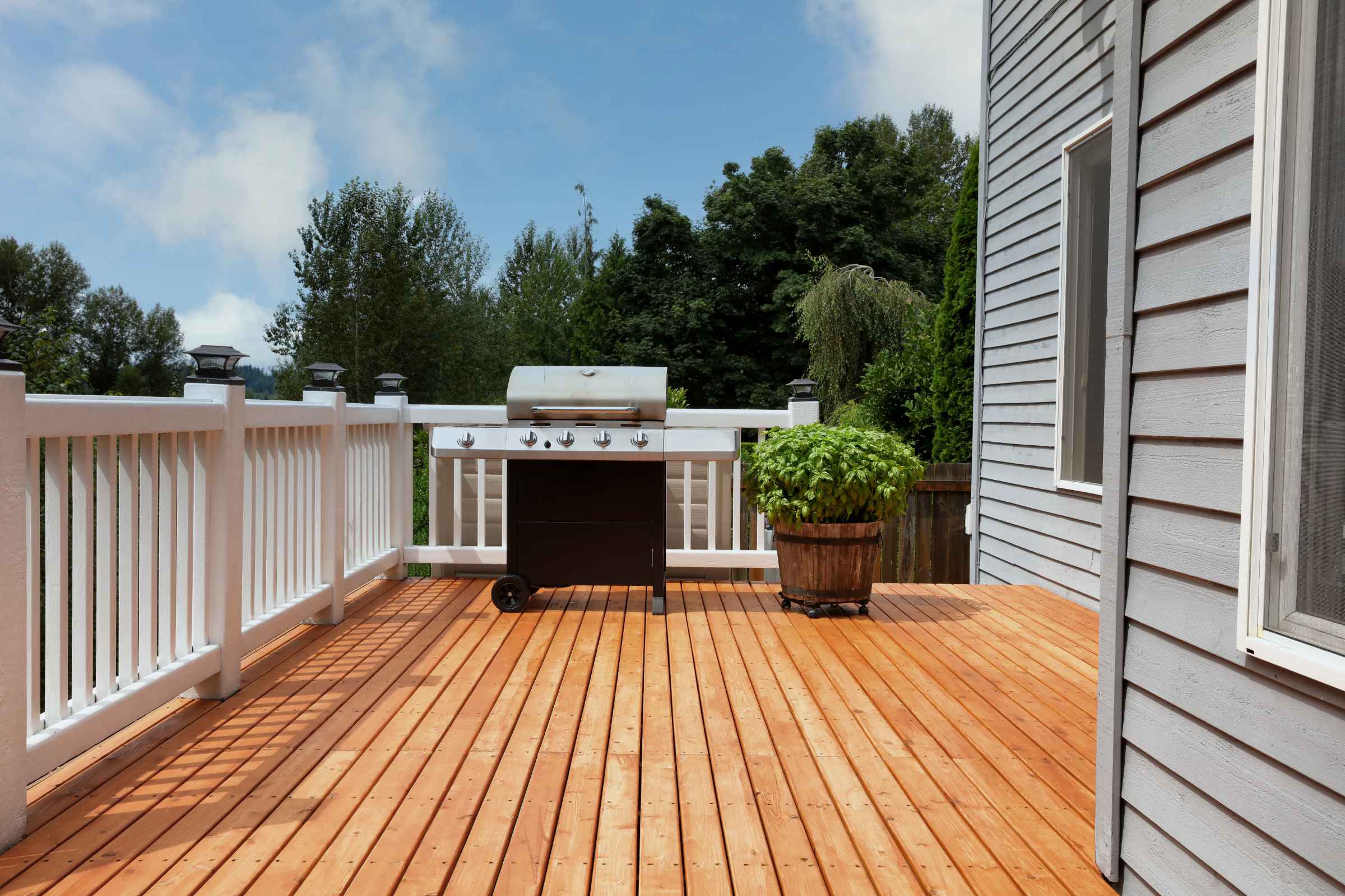 pressure treated deck with white railing and grill